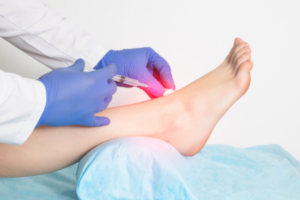 A doctor injecting a prolotherapy solution into a woman's ankle.